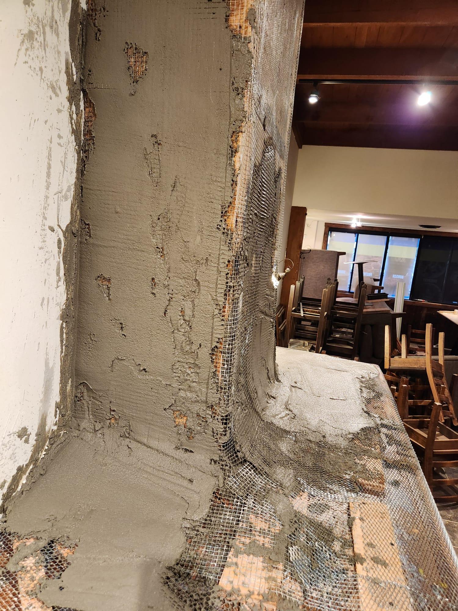 Mineral material being built up to shape the fireplace profile