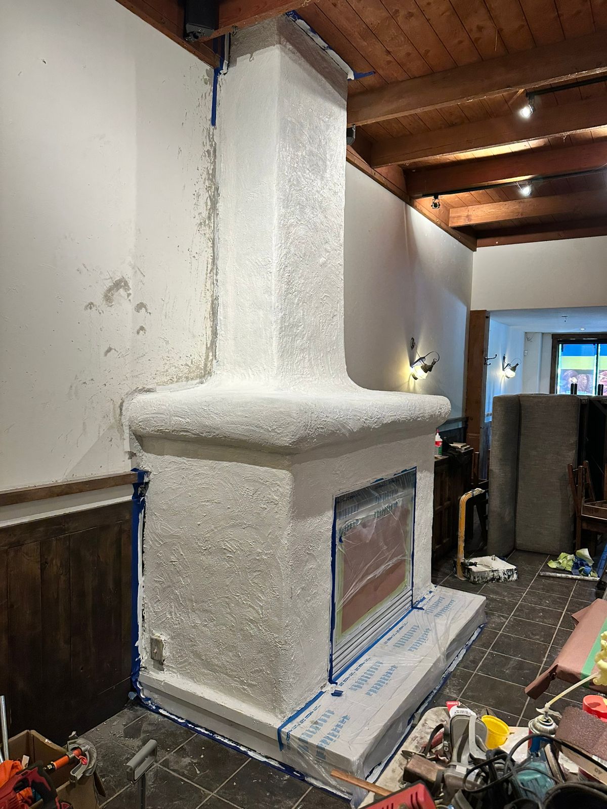 Protected fireplace receiving its white painted finish coat